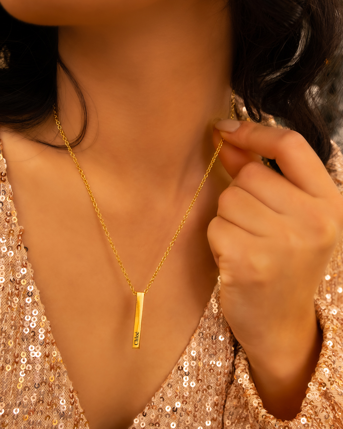 Model met een graveerbare bar ketting met naam in het goudkleurig