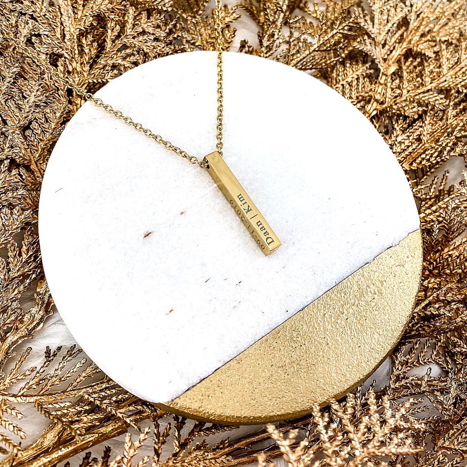 Gouden graveerbare ketting op een plaatje voor een complete look