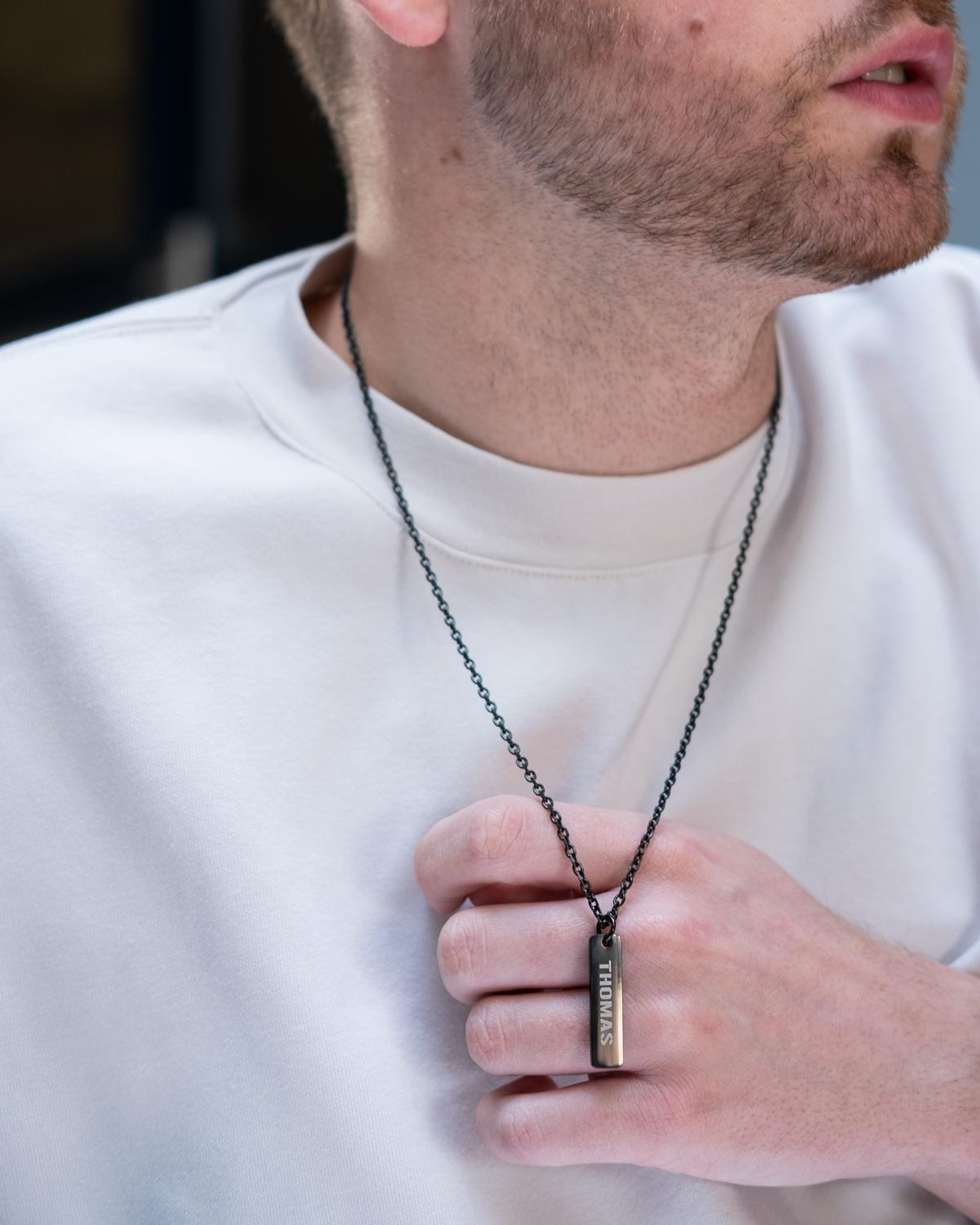 Zwarte heren ketting met naam bij wit t-shirt