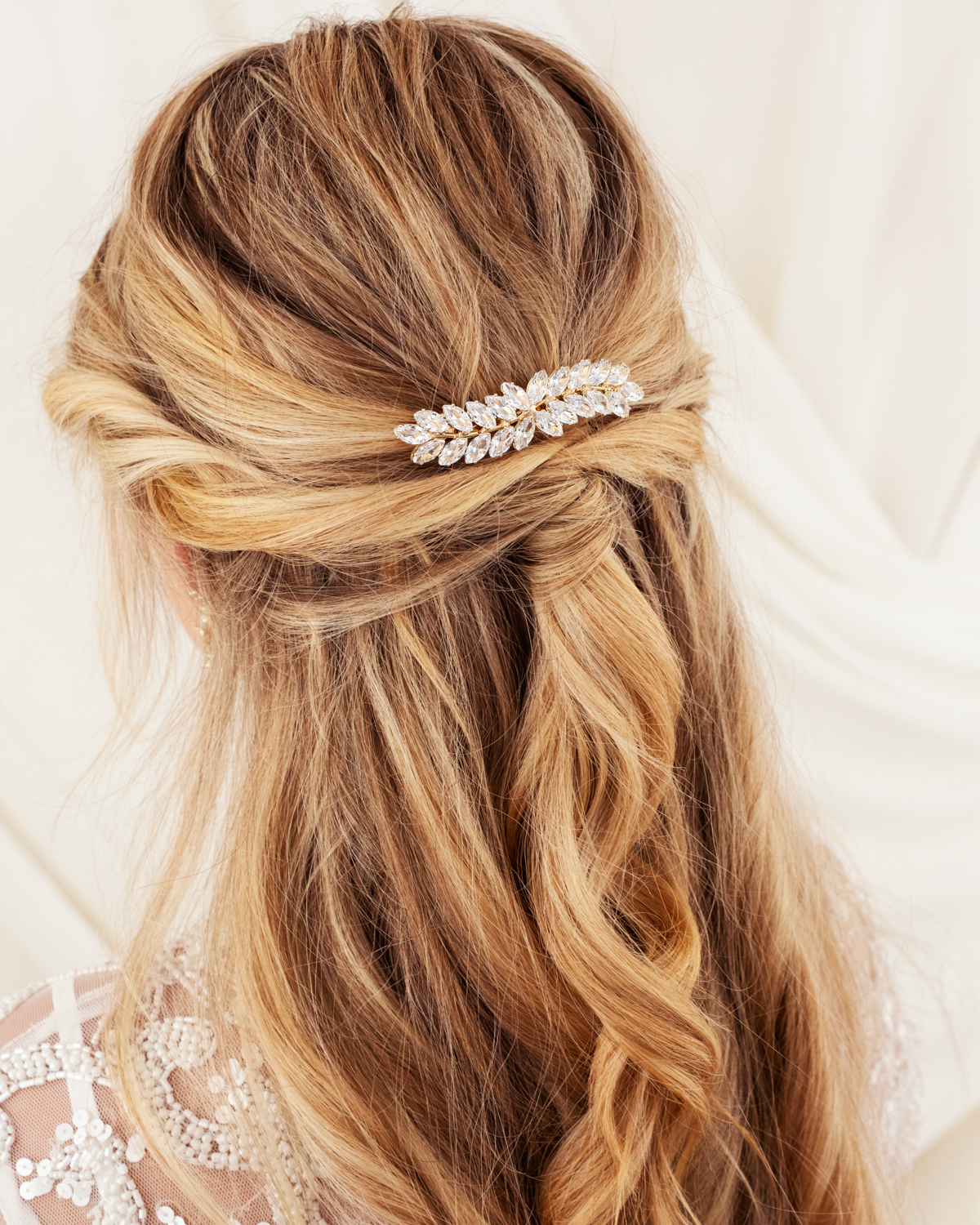 Model draagt gouden haaraccessoire