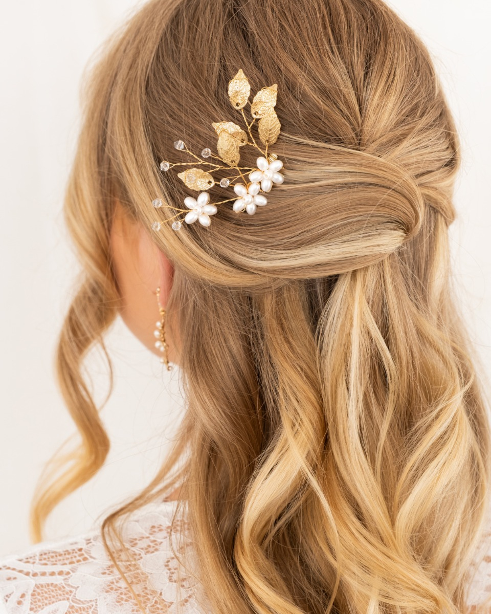 Bruid met haaraccessoire met parels en blaadjes