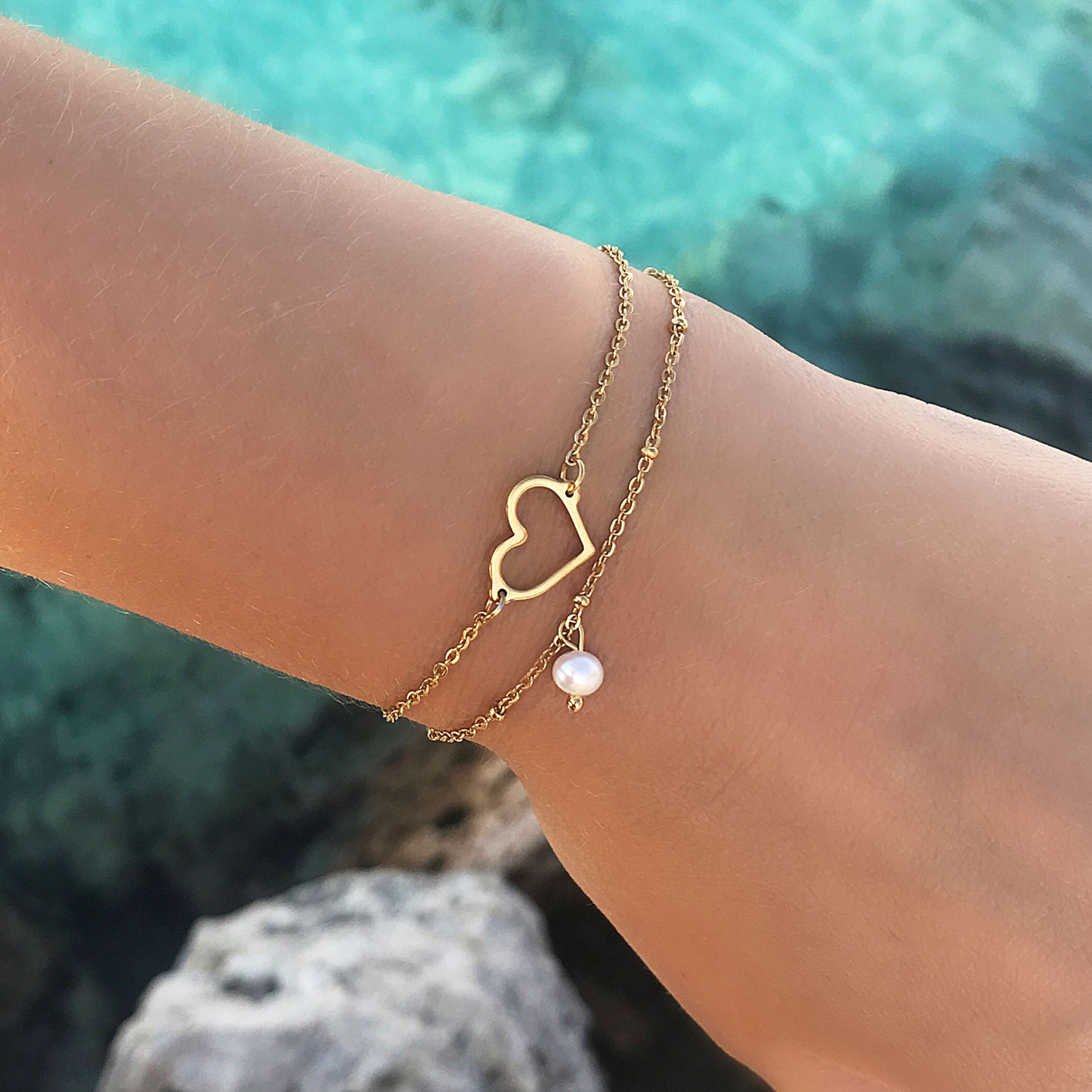 Leuke armband met hartje om de pols samen met minimalistische parel