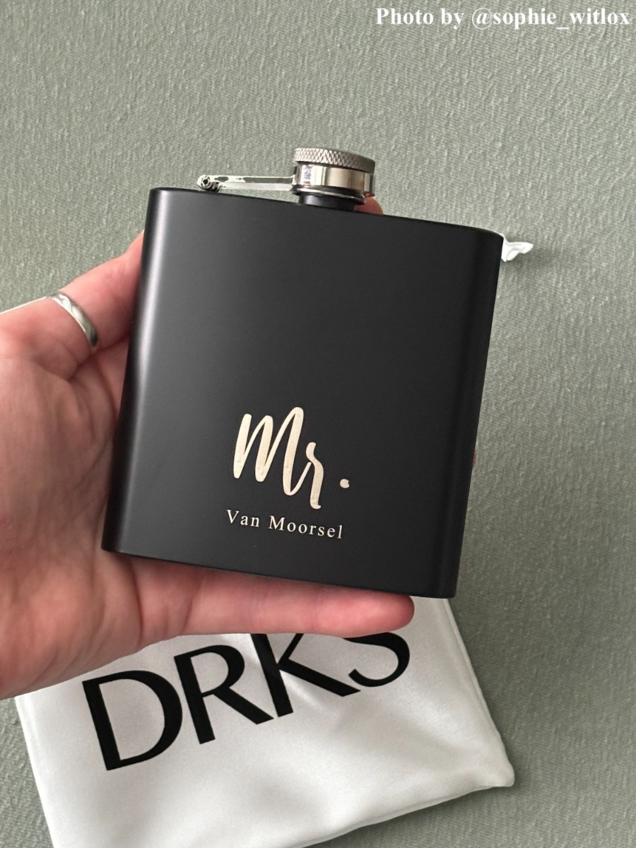 Influencer met zwarte heupfles met gravering