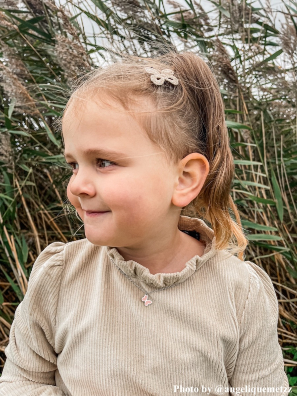 meisje draagt ketting vlindertje