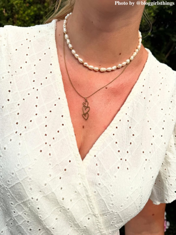 Influencer met parelketting en triple heart 