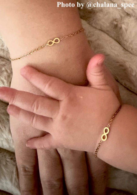 influencer draagt infinity armband goudkleurig met babytje