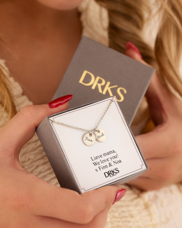 Zilveren ketting met twee muntjes met namen in sieradendoosje
