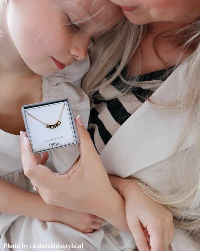 Influencer met goude letter ketting.