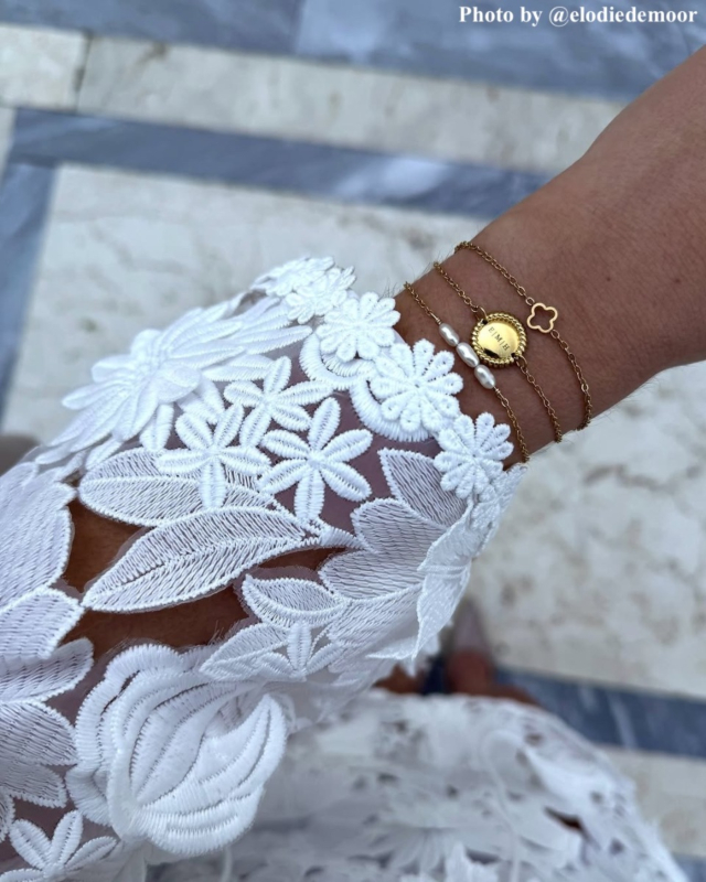Influencer met parelarmband, initial armband en klaver armband