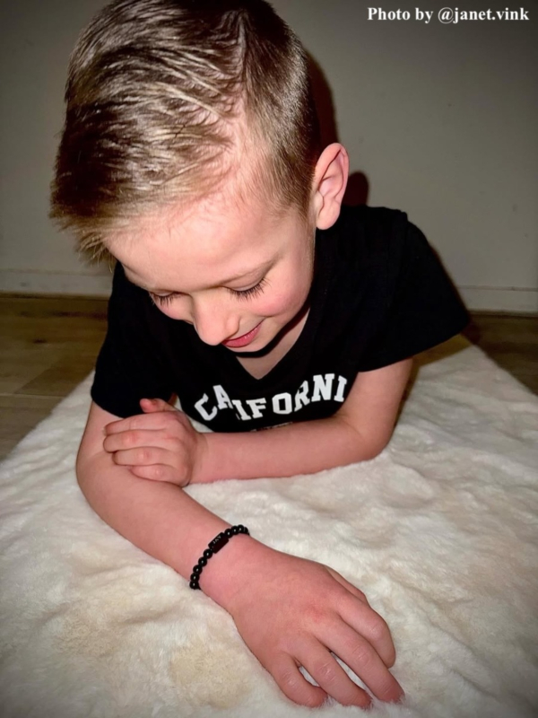 Jongetje draagt zwarte armband met naam