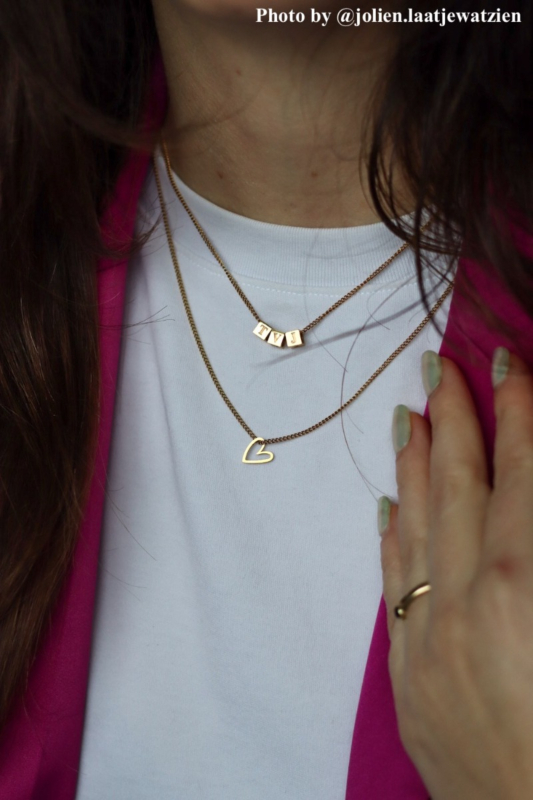 Model met de ketting met hartje goud kleurig.