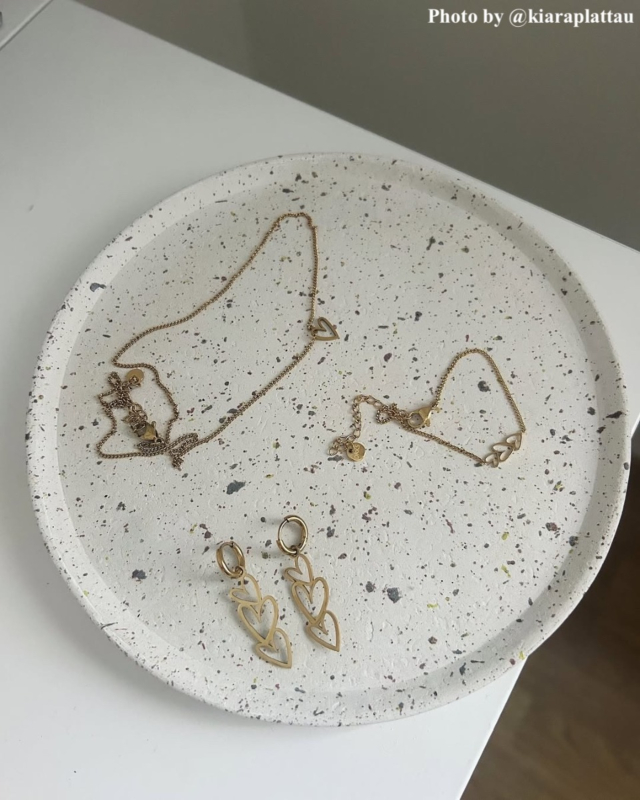 Influencer met de oorbellen triple heart goudkleurig.