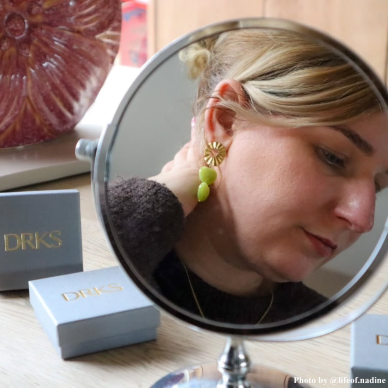 Influencer draagt groene hartjes oorbellen