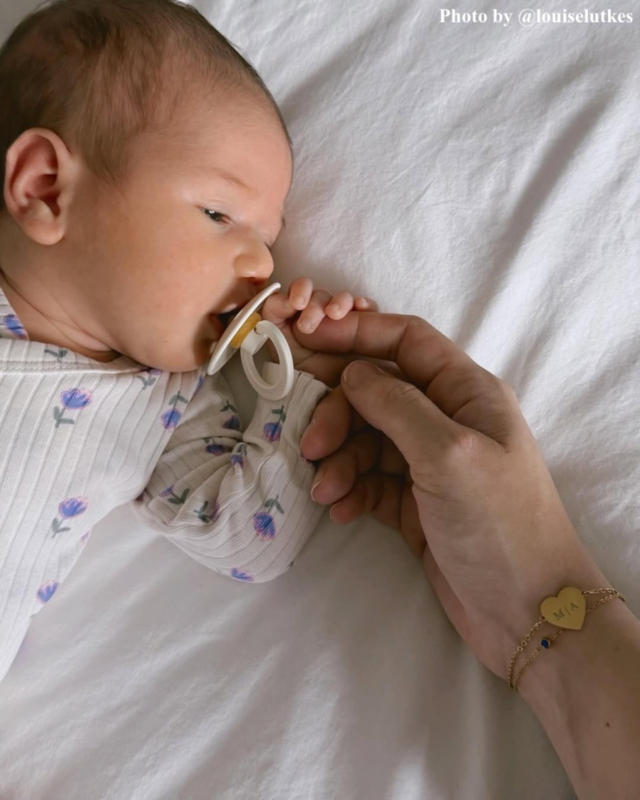 influencer draagt graveerbare armband M | A goudkleurig met babytje ernaast