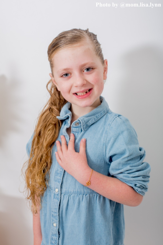 kindje draagt dubbel hartjes armband goudkleurig