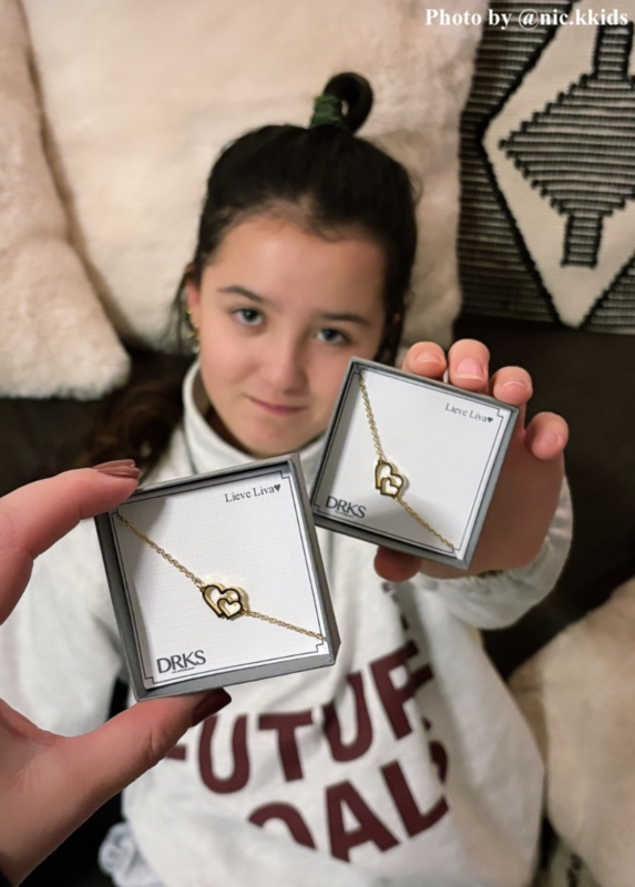 influencer heeft met dochter samen armbandje vast in doosje