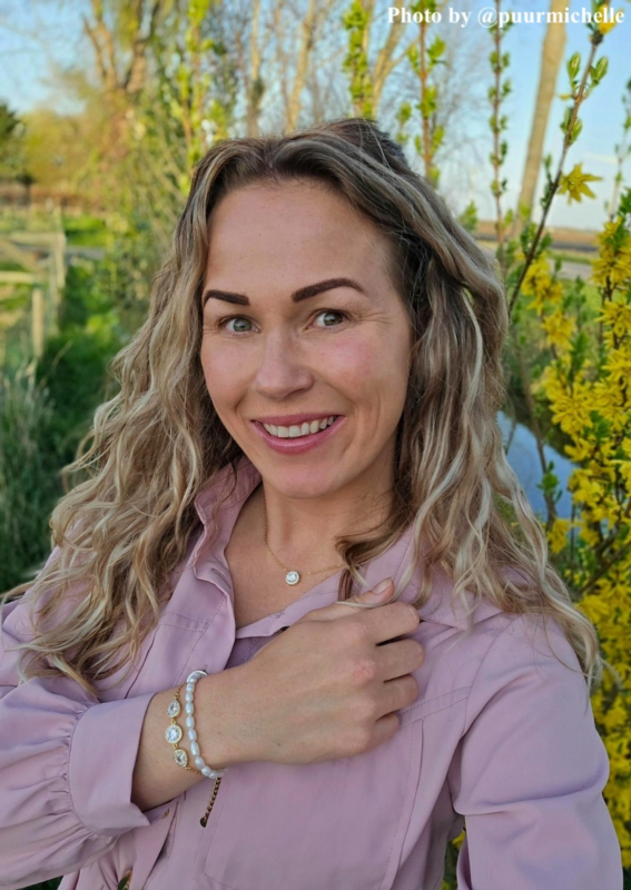 Influencer met gouden/parel armbanden en ketting