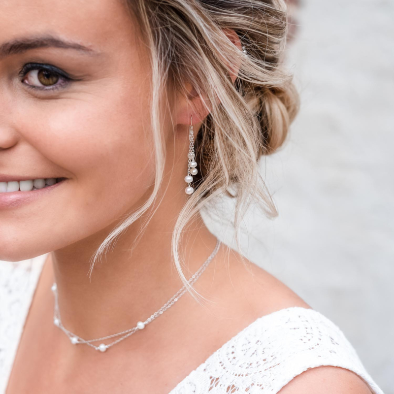 Bruid draagt een mooie set van oorbellen met een ketting om de hals