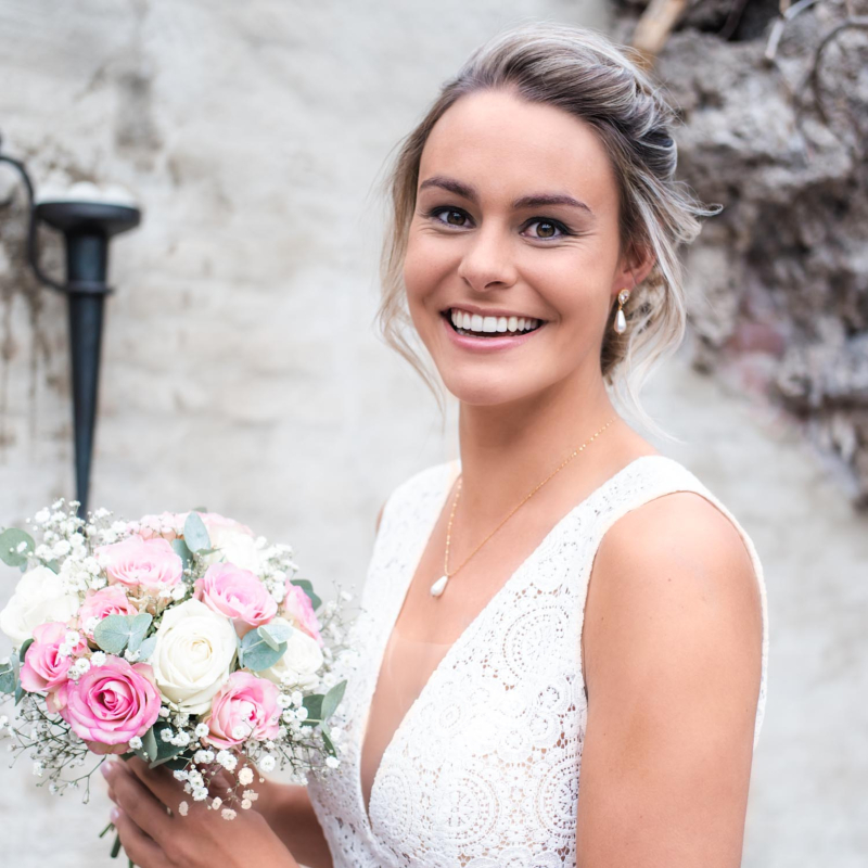 Bruid draagt een mooie parelketting samen met de oorbellen voor haar dag