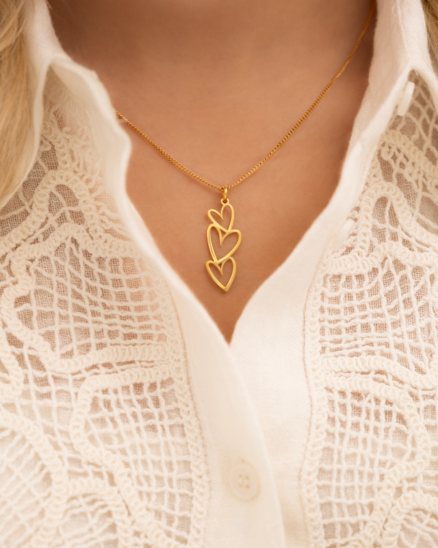 Model draagt gouden hartjes ketting