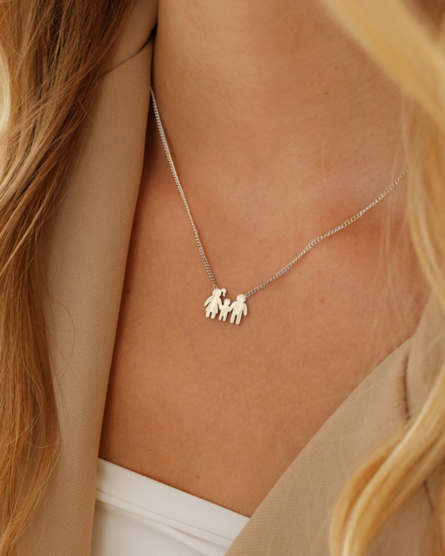Model draagt zilveren ketting met man, vrouw en kind
