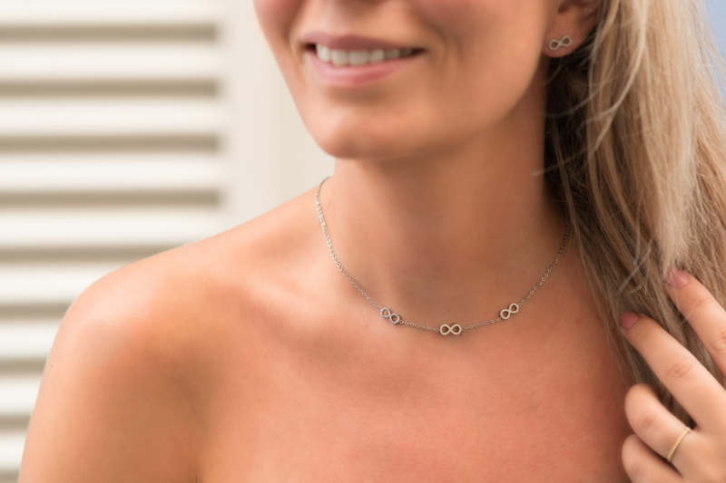 zilveren infinity ketting om de hals met leuke tekens