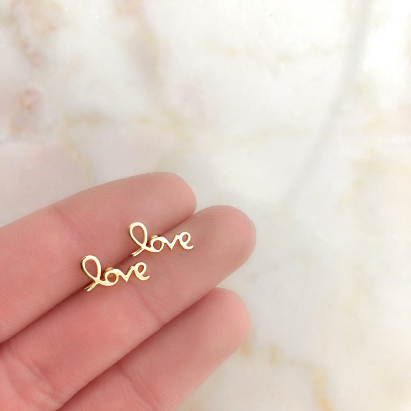 Mooie look met goudkleurige oor studs in de hand