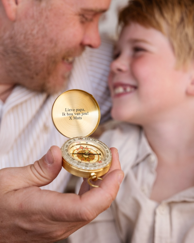 vader en zoon met gouden kompas met gravering