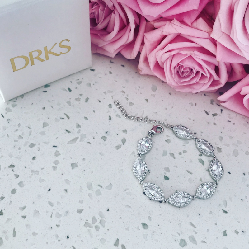 Mooie zilveren sparkle armband op marmeren plaatje met rozen