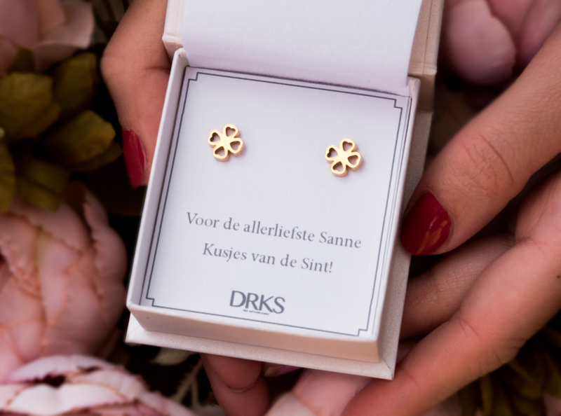 Gouden oorbellen met klavertje in een sieradendoosje