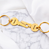 Gouden sleutelhangers met hartje op marmeren ondergrond