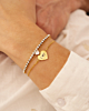 Model draagt mix van gouden armbanden