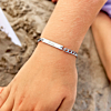 Kindje draagt zilveren armband met gravering