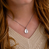 Vrouw draagt zilveren sea shell ketting