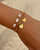 Gouden armparty met hartjes en steentjes