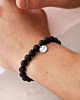 Zwarte kralen armband met zilver muntje met gravering