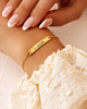 Model draagt gouden bar armband met naam