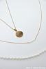 Influenceer met de DRKs drie parel ketting. 