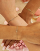 Gouden armbanden met hartjes om polsen