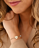 Model draagt zilveren hartjes armband met gravering