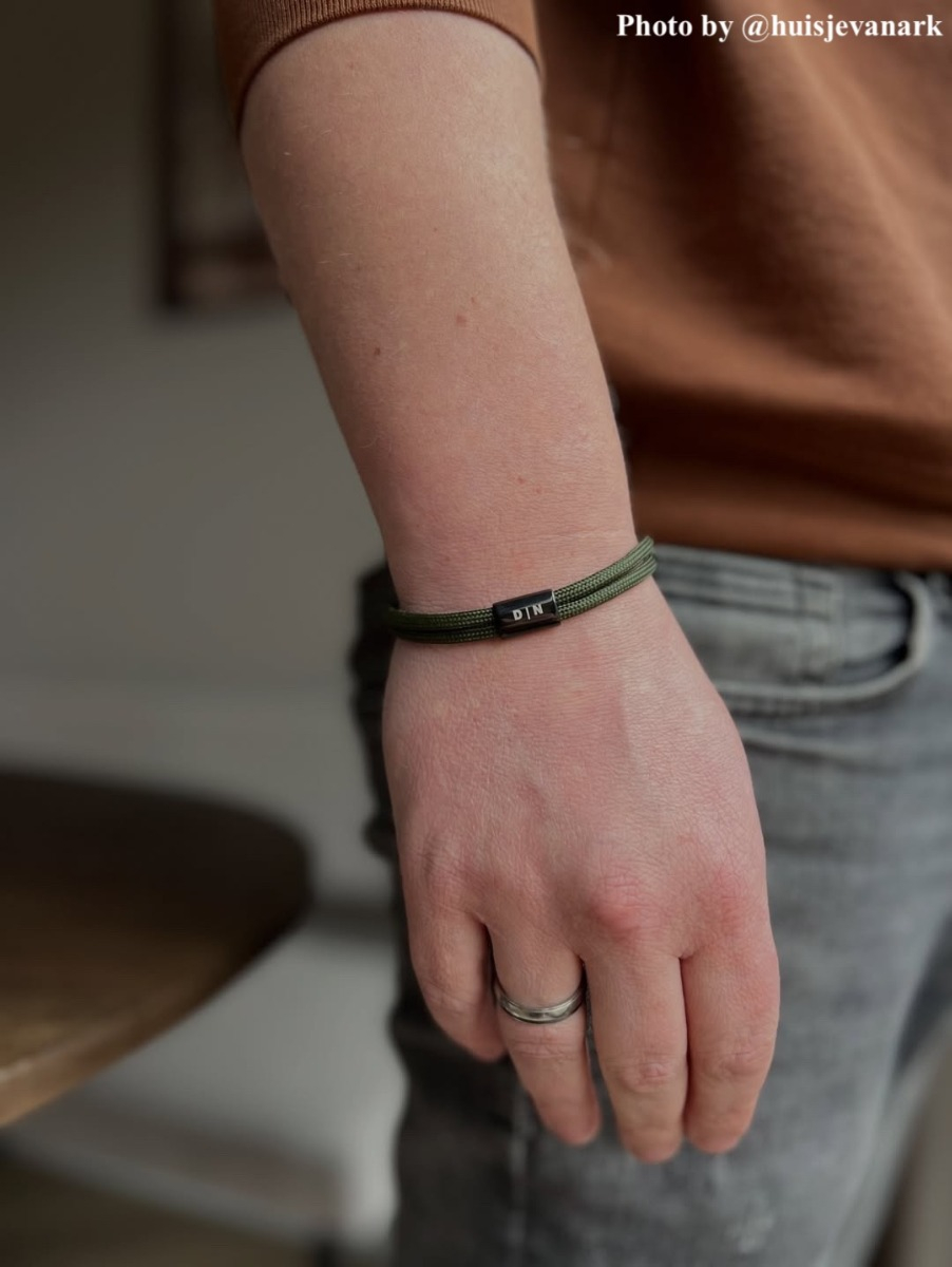 influencer draagt armbandje met letters D | N in het groen