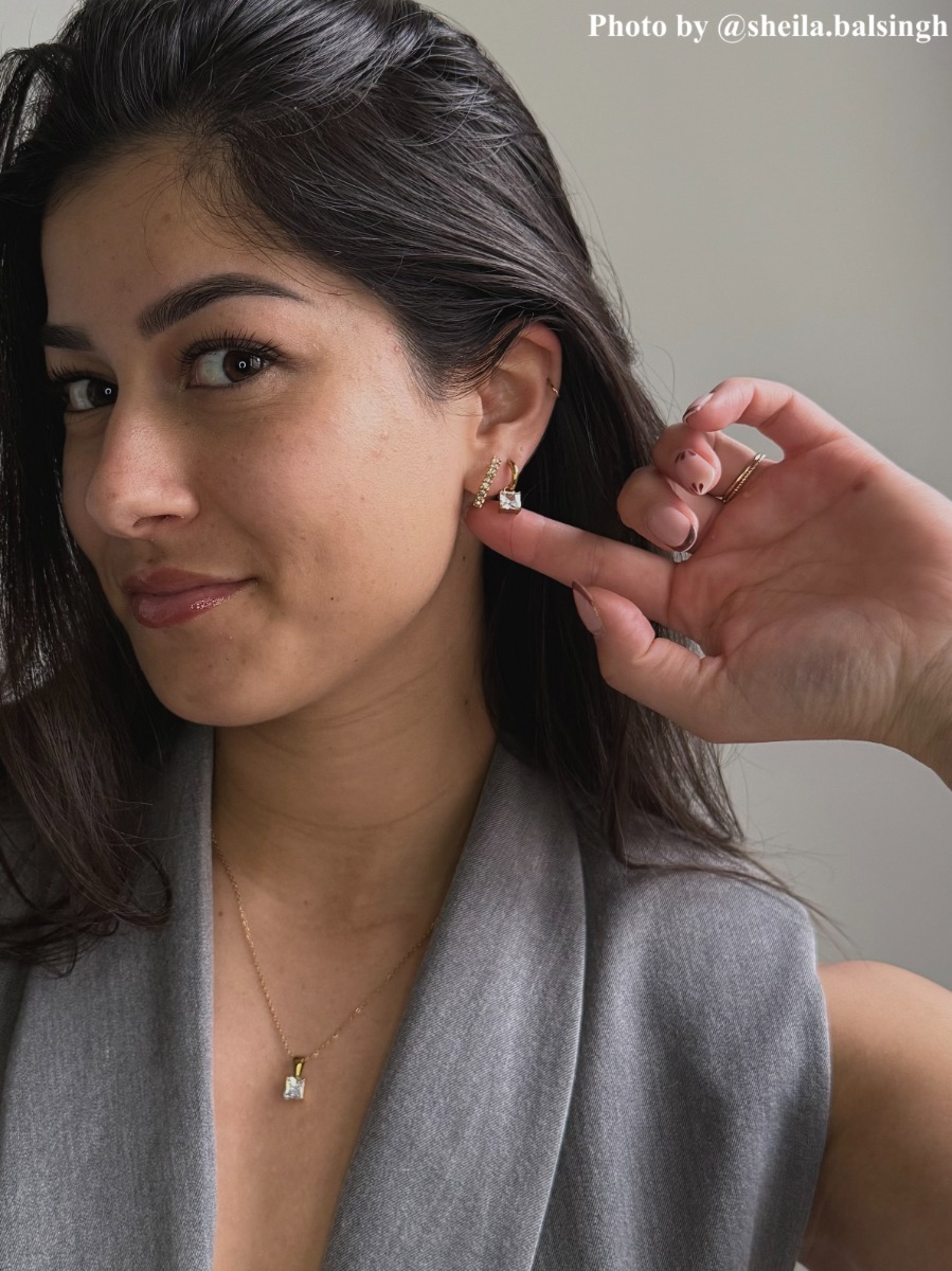 Influencer met gouden/crystal oorbellen, ringen en ketting