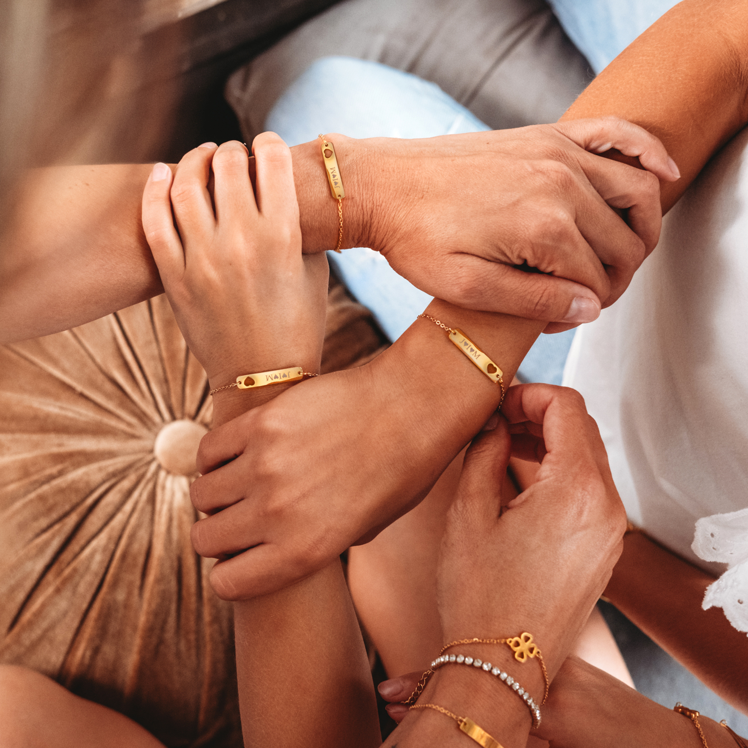 gouden armbanden met uitgesneden hartje om polsen