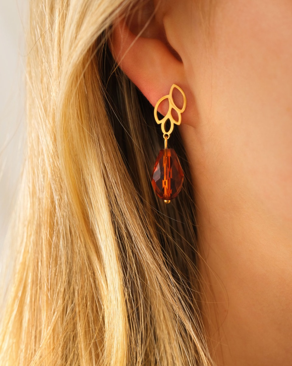 Model met gouden oorbel met bruine steen