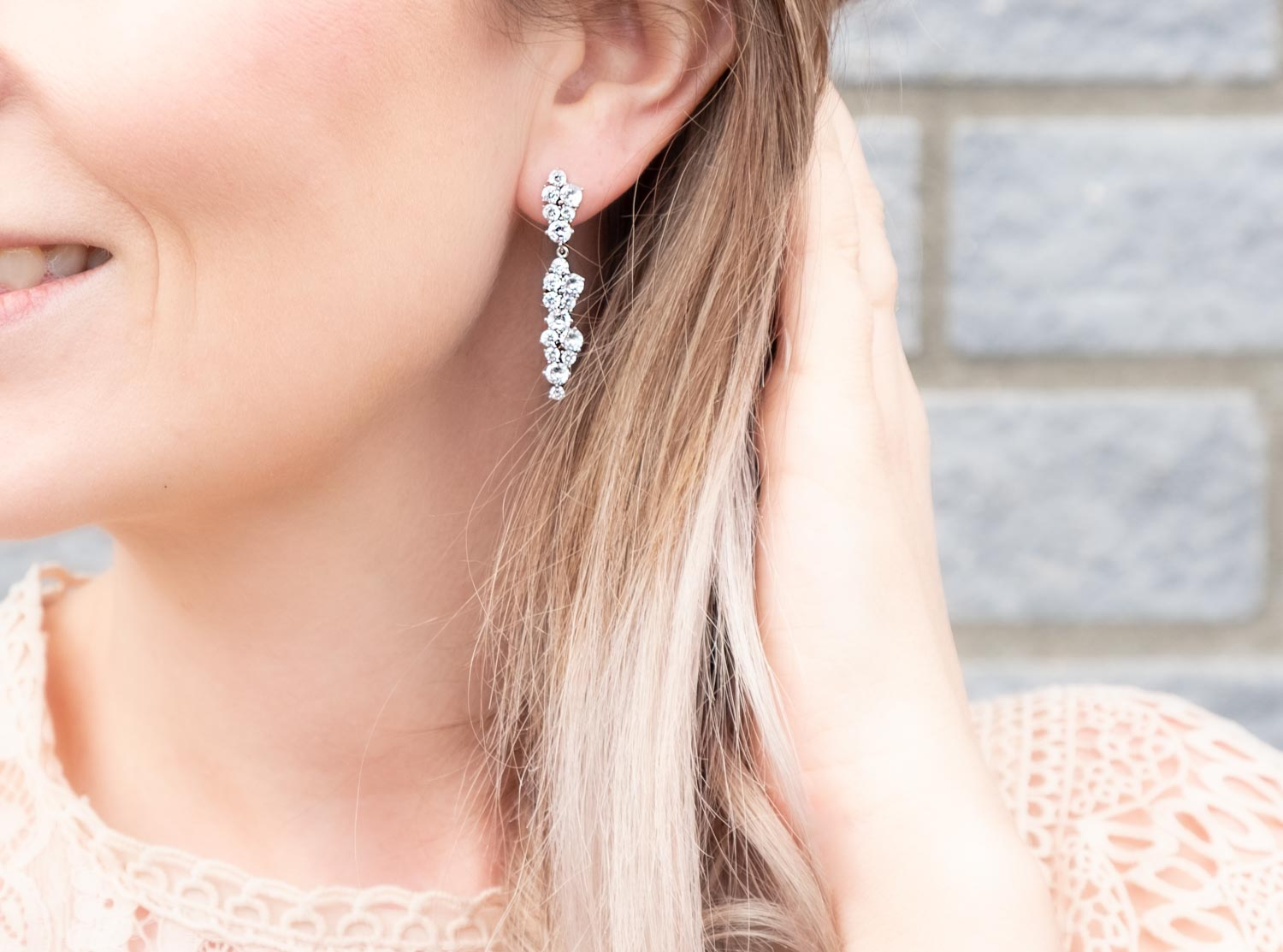 Vrouw draagt elegante lange oorbellen in het zilver