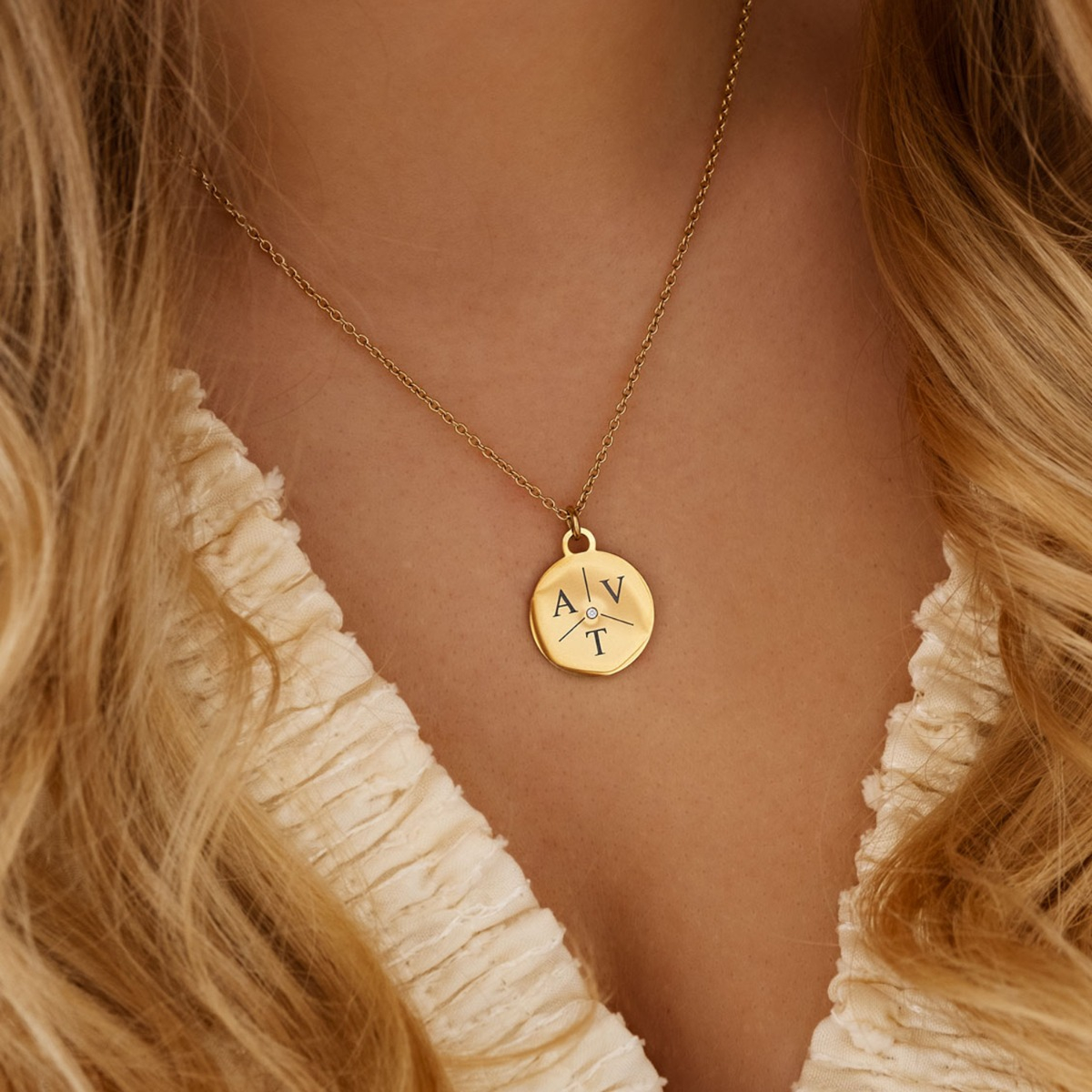 gouden ketting met drie letters en steentje in het midden