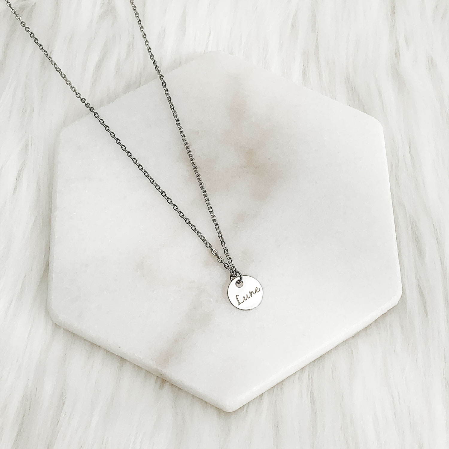 zilveren ketting met muntje op een plaatje om te kopen
