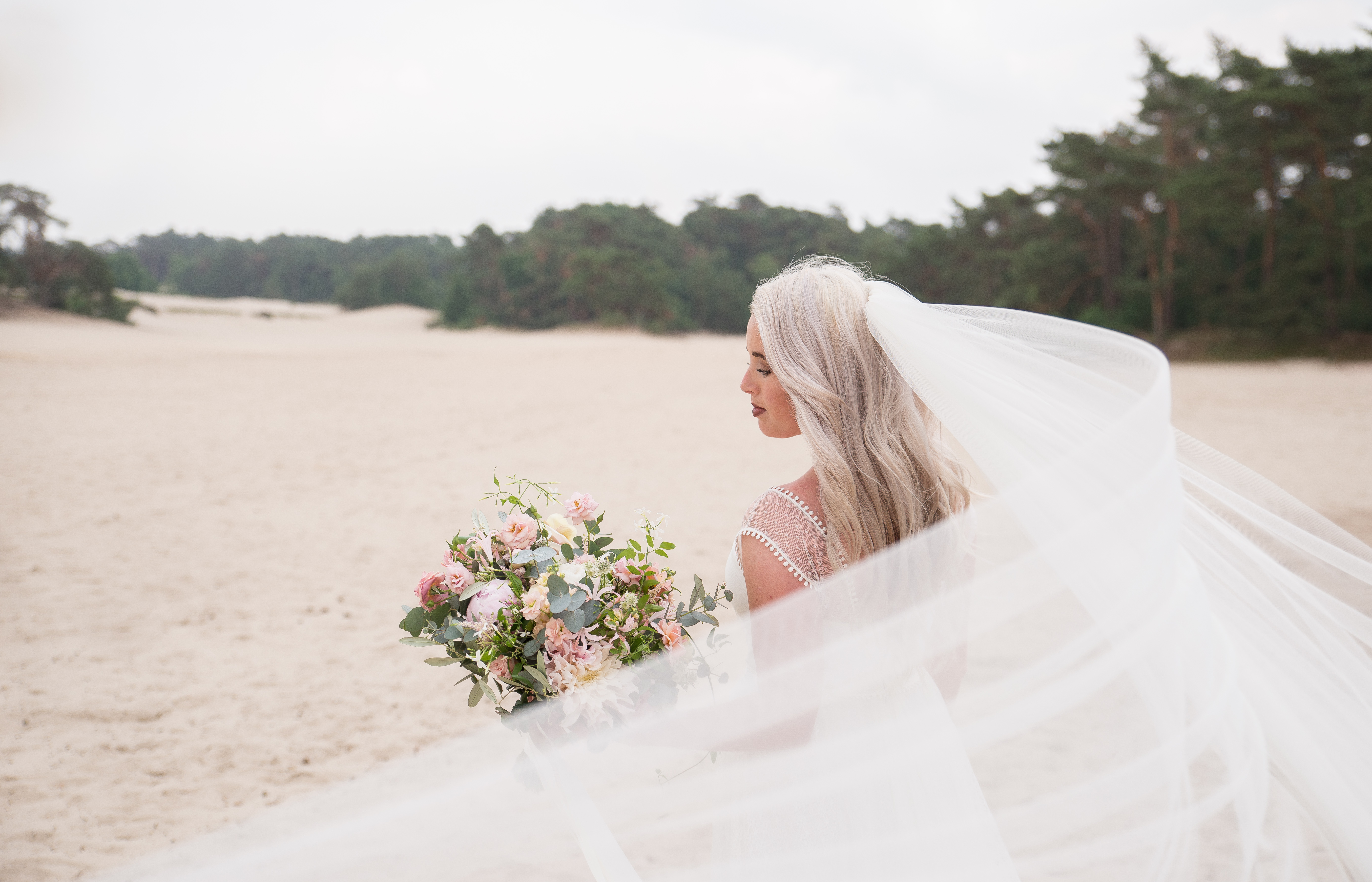 bruid op strand met boeket