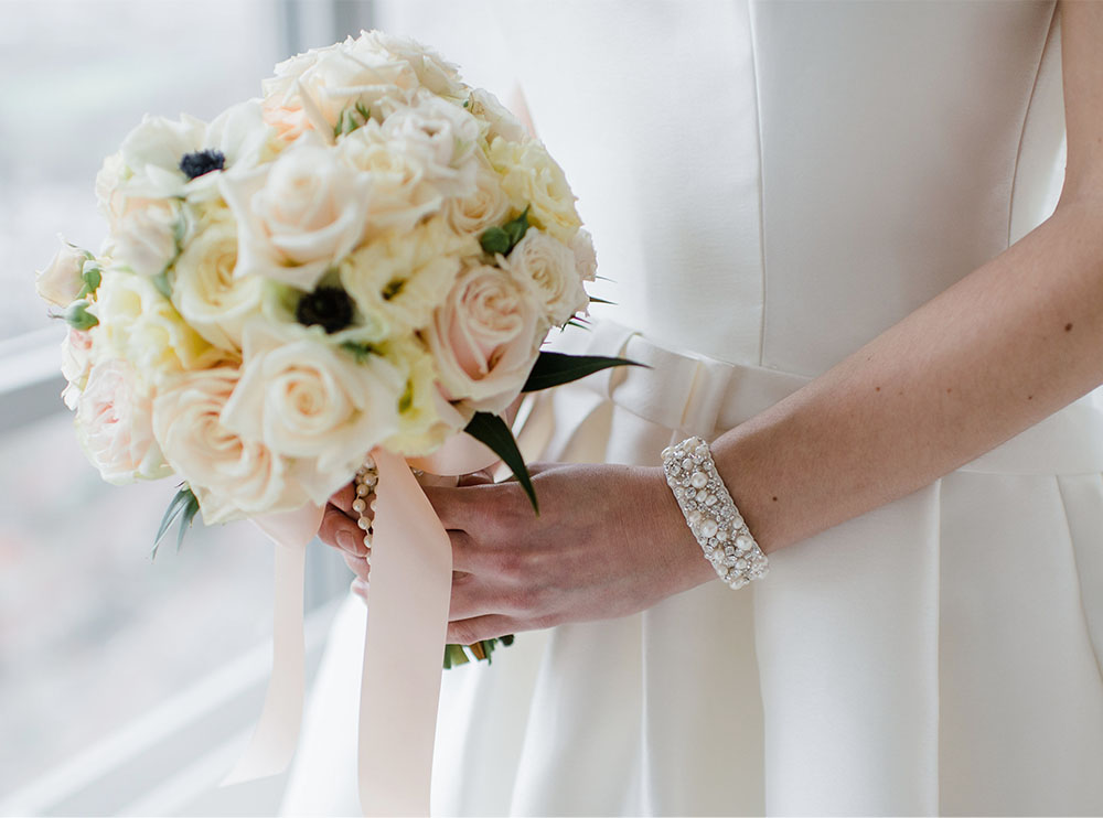 Bruid met bruidsarmband en boeket