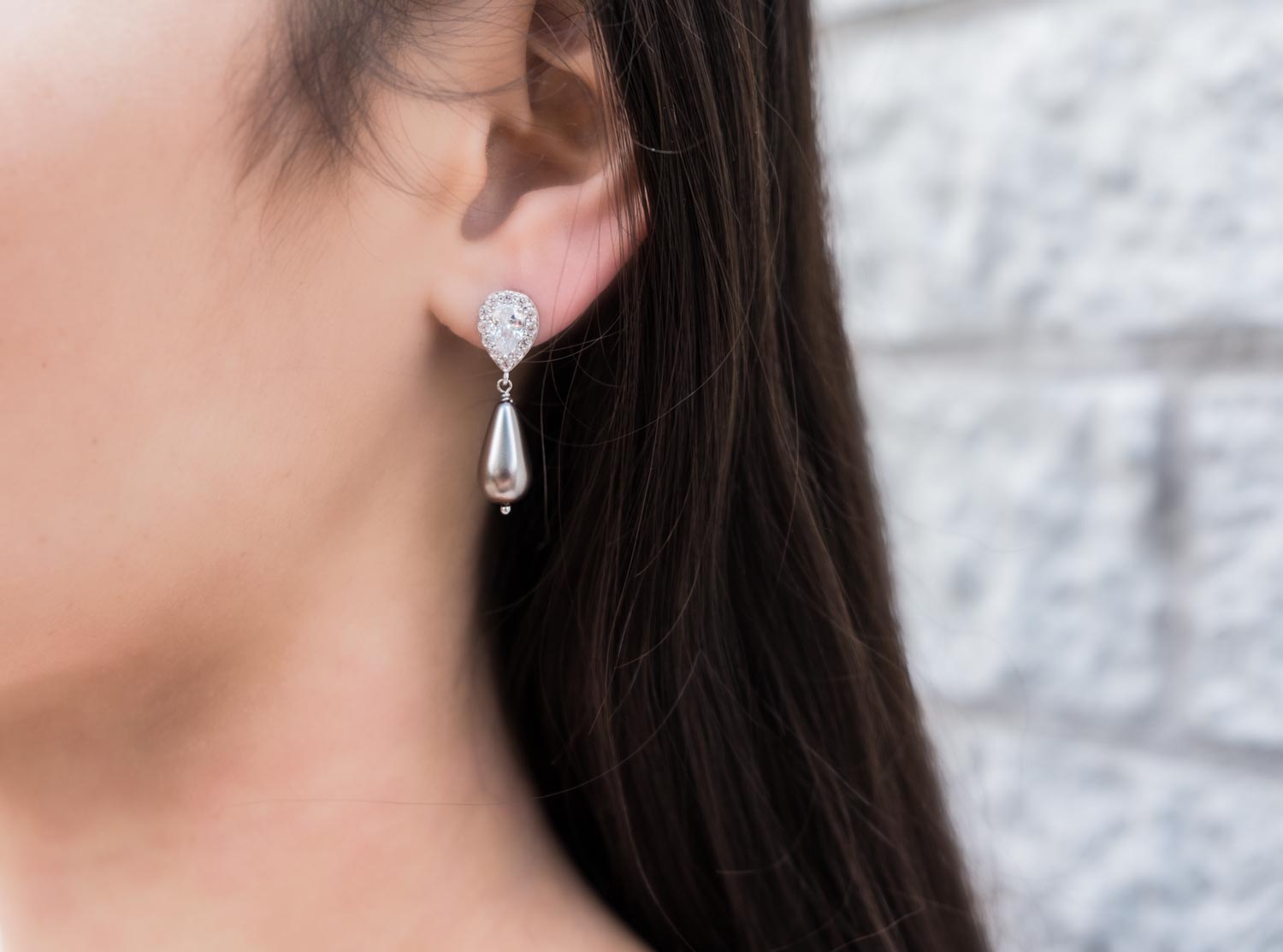 Meisje draagt grijze parel oorbellen